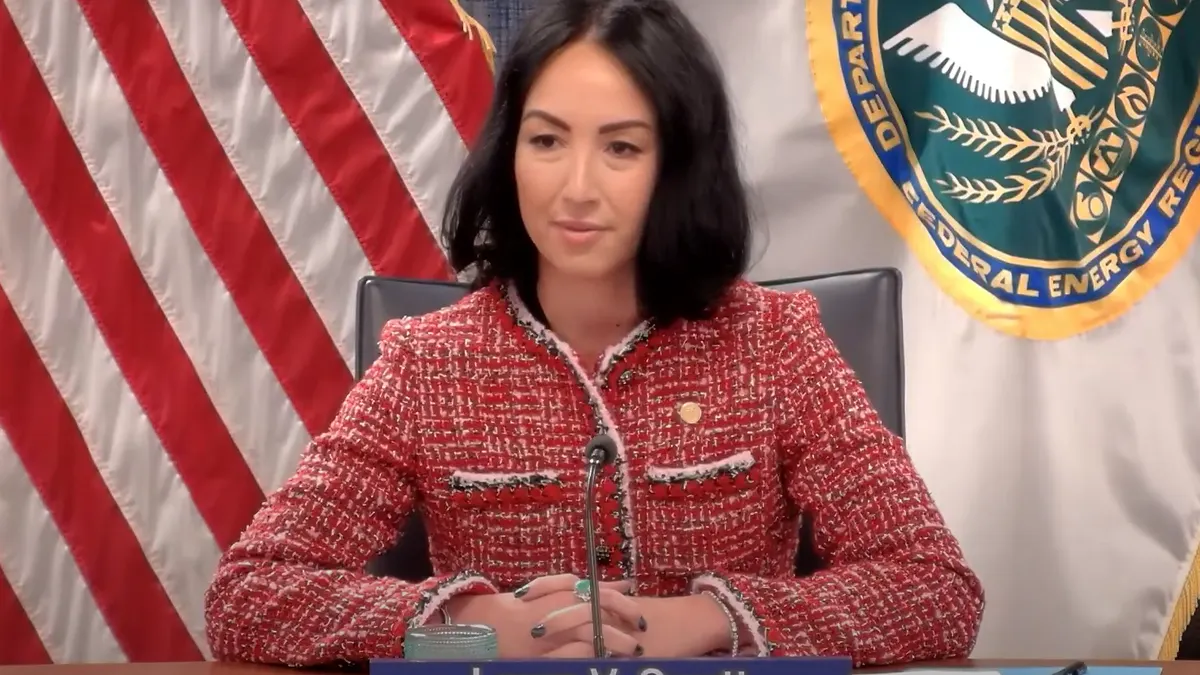 A woman sits at a dias.