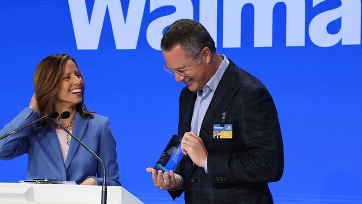 Two people laughing in front of the Walmart logo