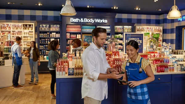 People look at an iPad inside a Bath & Body Works store