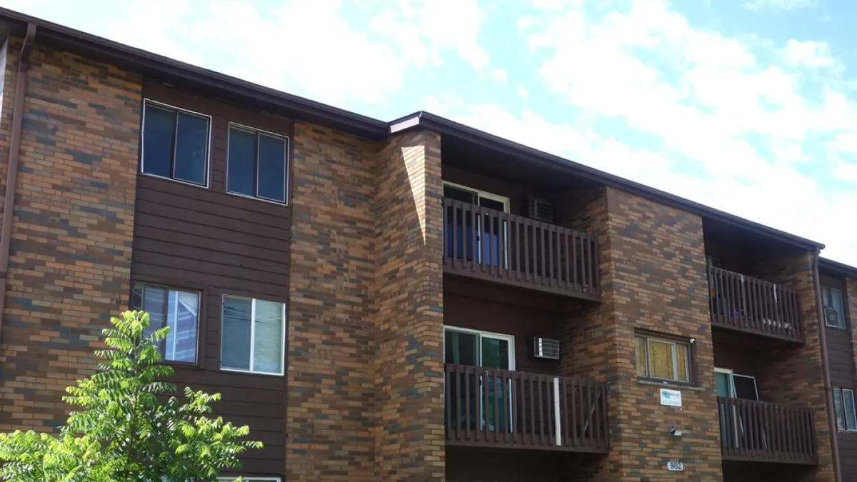 A garden-style brick apartment building.