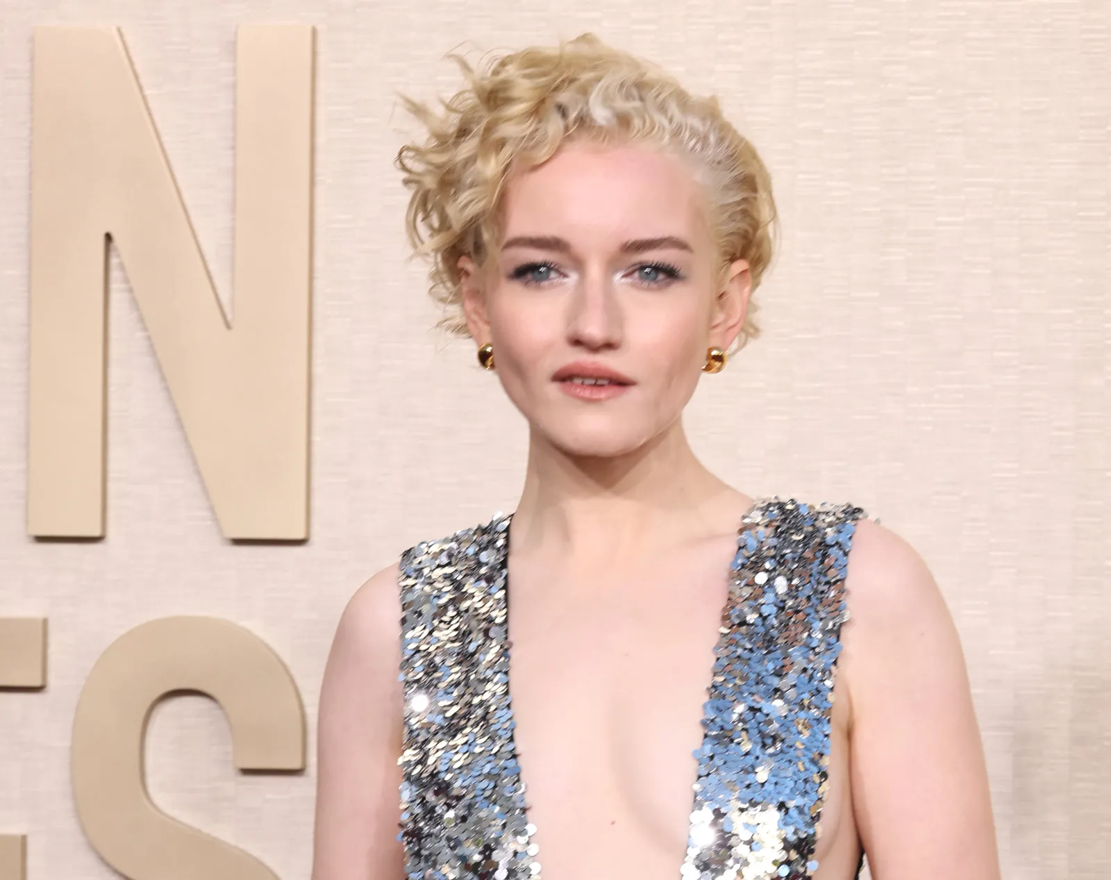 Julia Garner wears a dress with silver sequin shoulders.