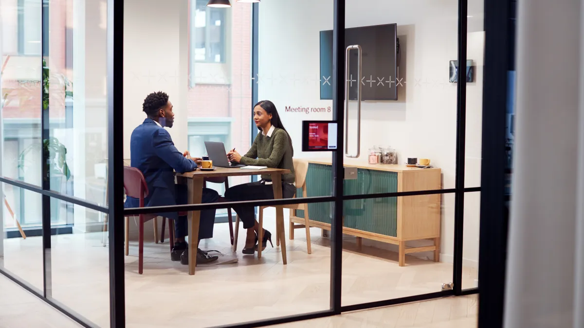 Businesswoman Interviewing Male Job Candidate In Meeting Room