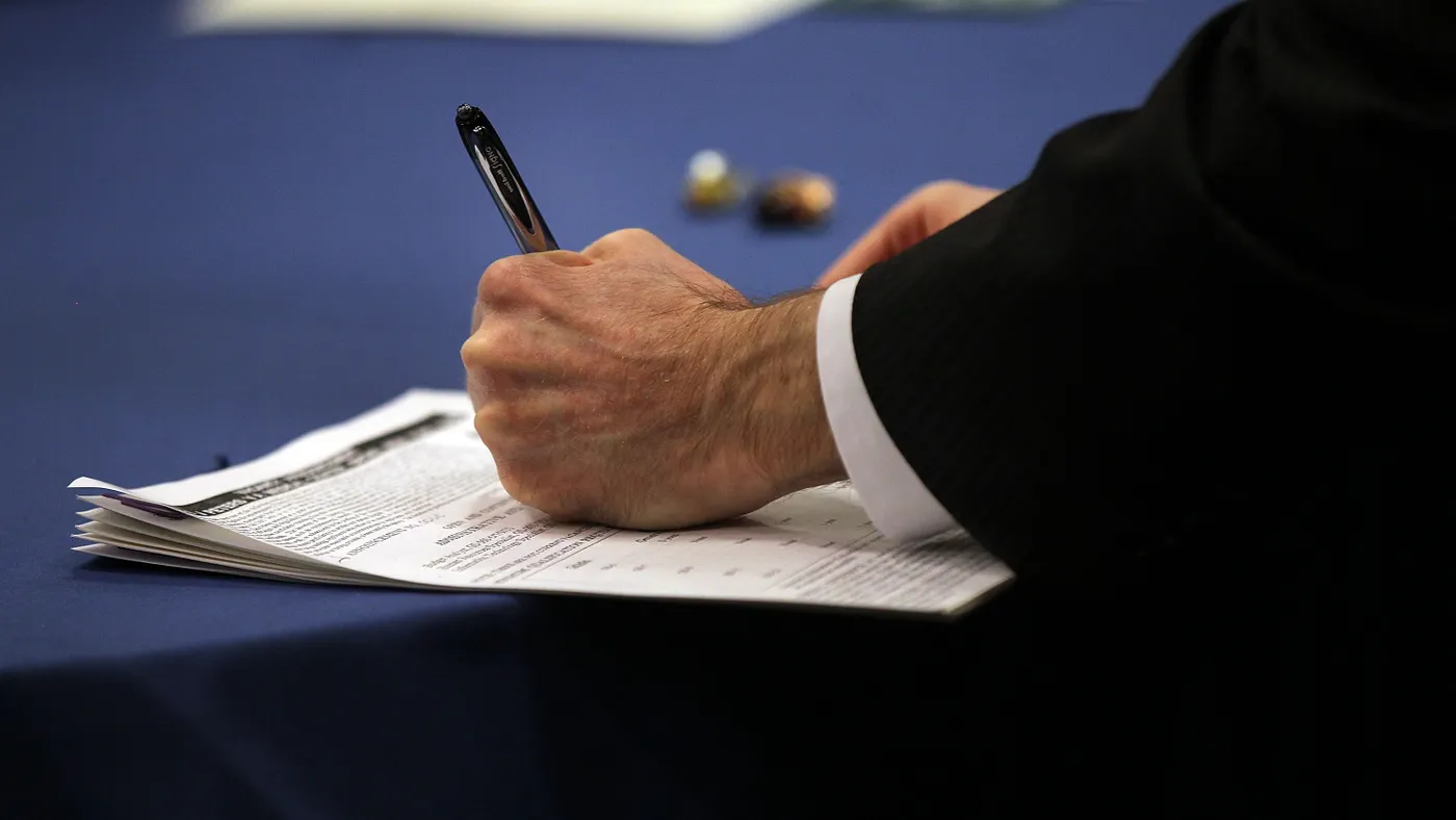 A closeup of a person filling out a paper job application.