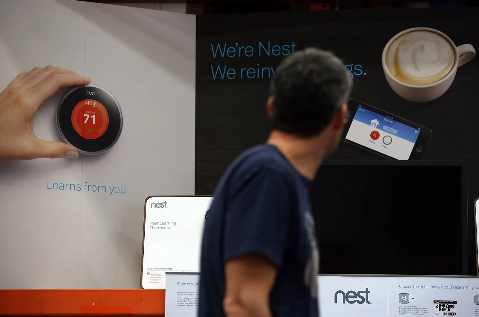 A person walks by a diplay for the Nest smart thermostat at a Home Depot store