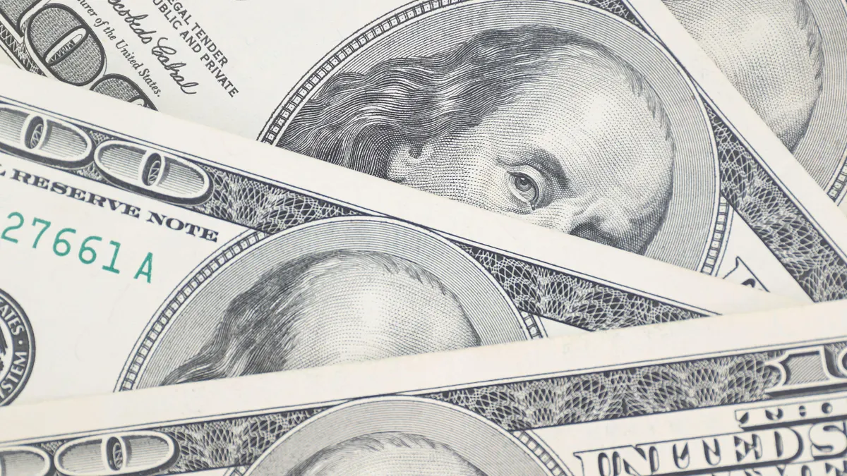 A stack of US one hundred dollar bills is spread out on a table. 