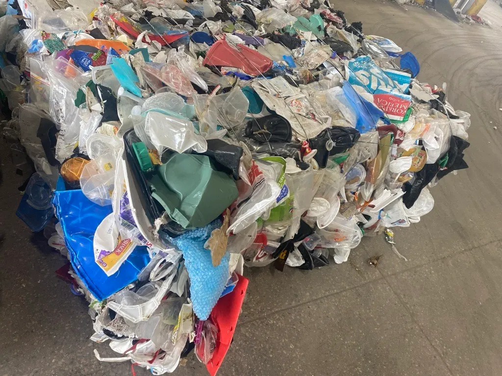 A bale of mixed plastic packaging at a recycling facility.