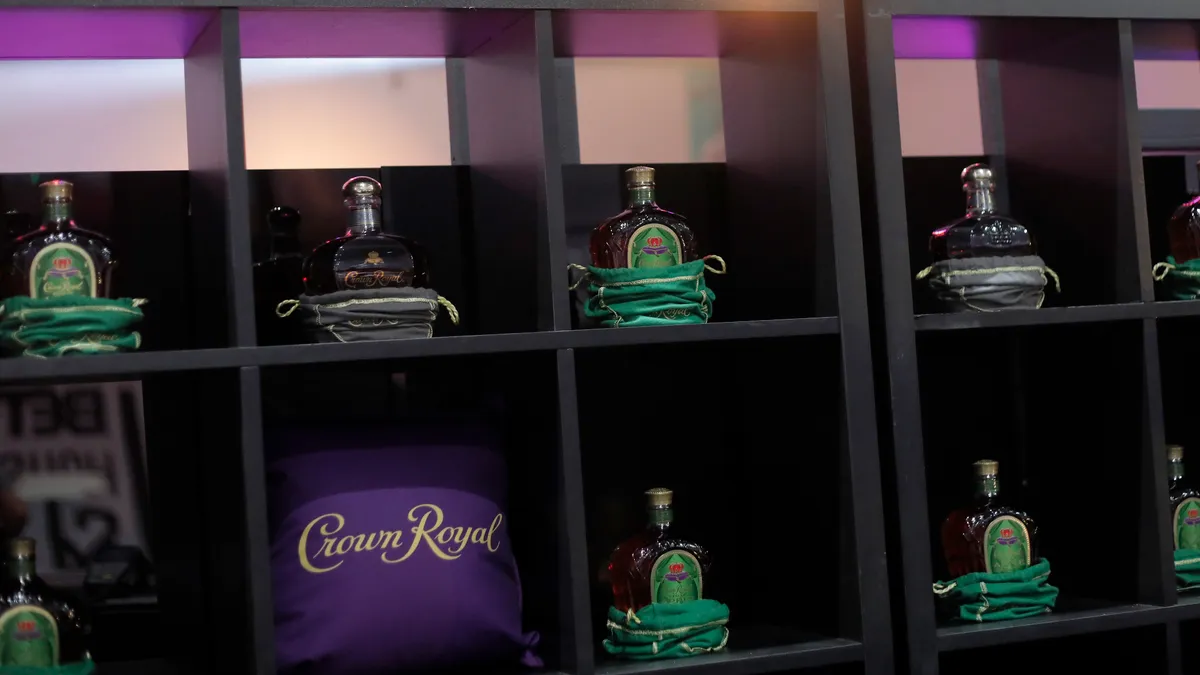 Bottles of Crown Royal sit on shelves.