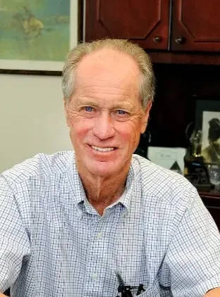 A head and shoulders photo of a person in an office.