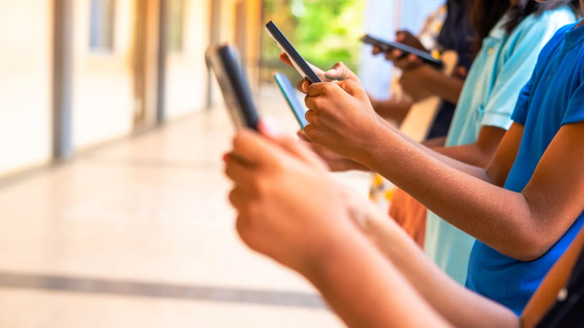 A row of students holding their cellphones.