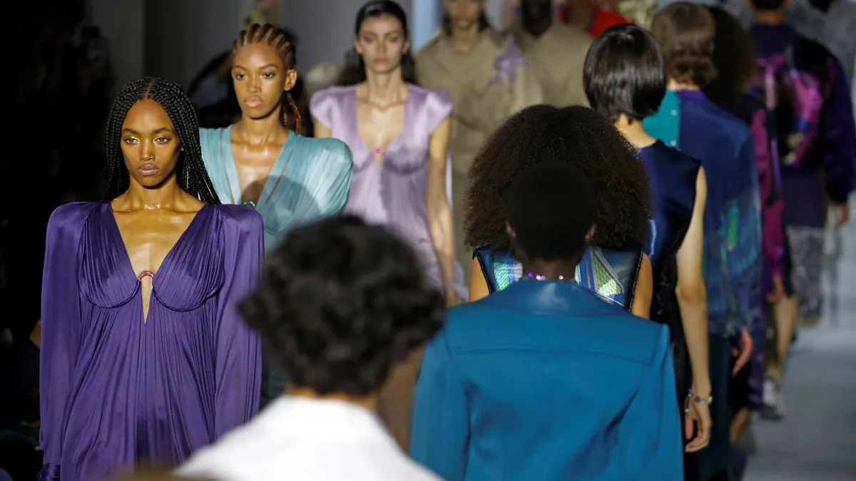 Models walk both toward the camera and away from the camera on a runway.