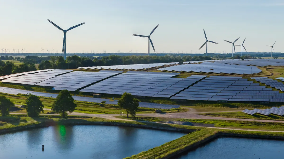 Solar power plant and wind turbines next to the lake