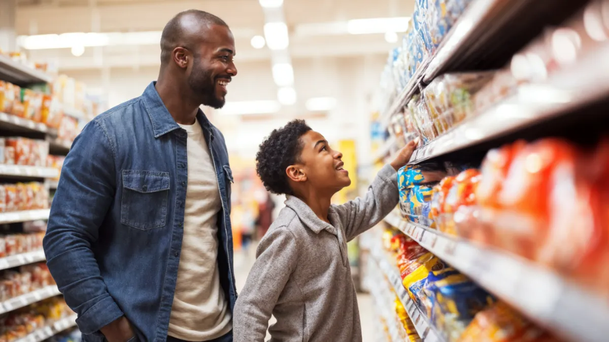 A man and child in the grocery store aisle.