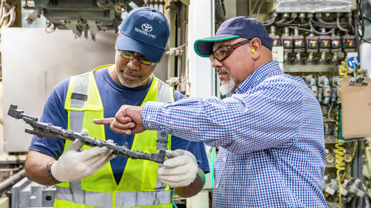 Two workers inspect an engine component at Toyota's engine plant in Missouri.