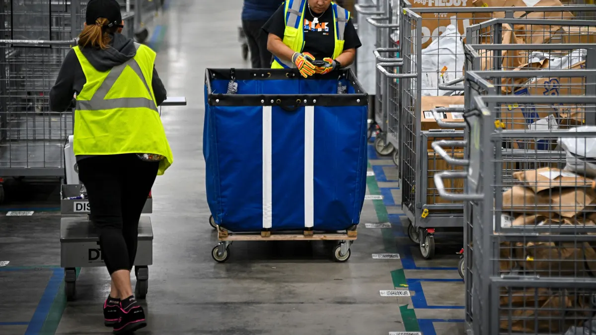 Employees move packages in a warehouse.